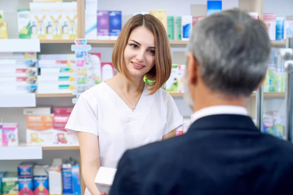Apothekerin berät einen Kunden in der Apotheke